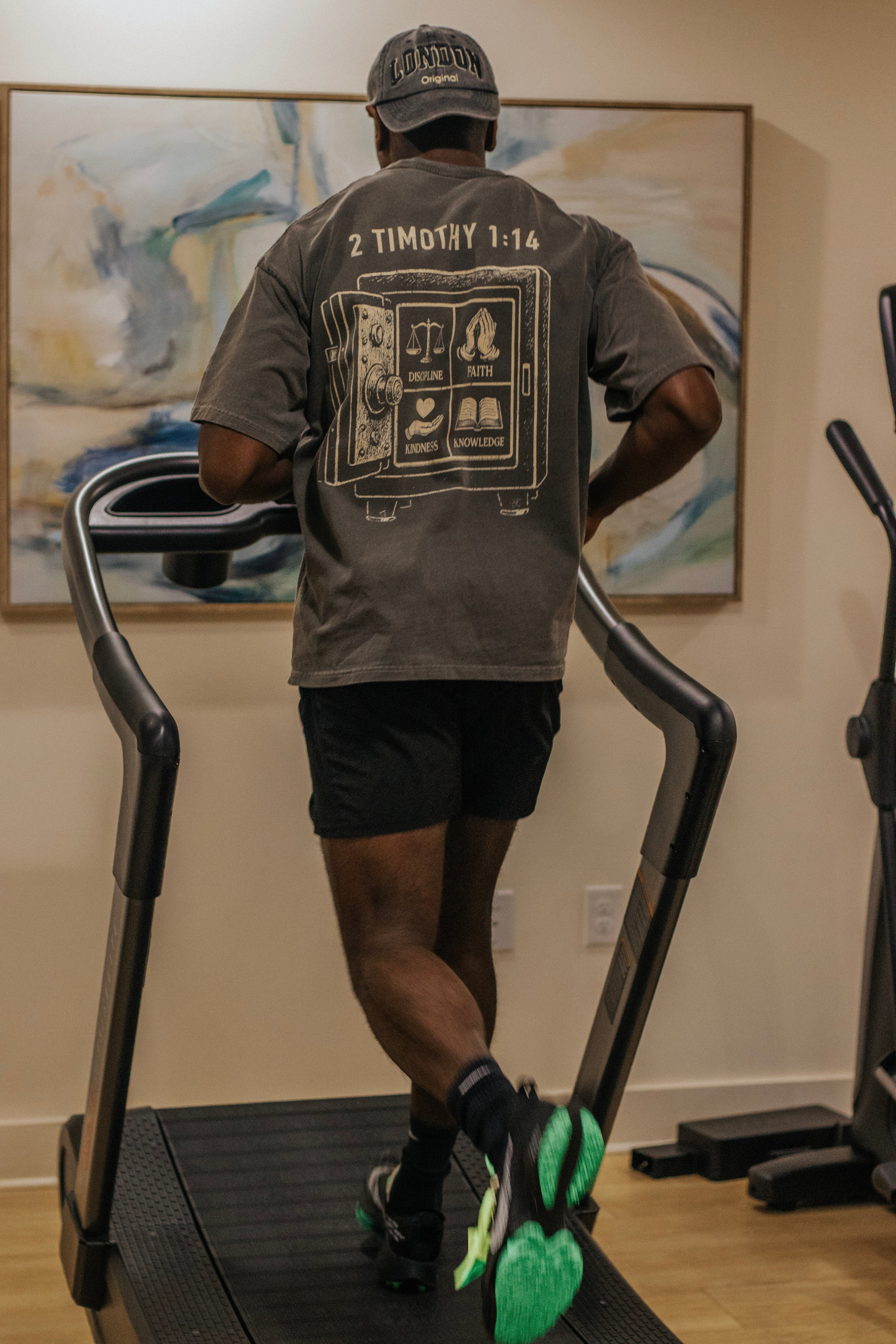 Person using a treadmill in a room with a painting on the wall